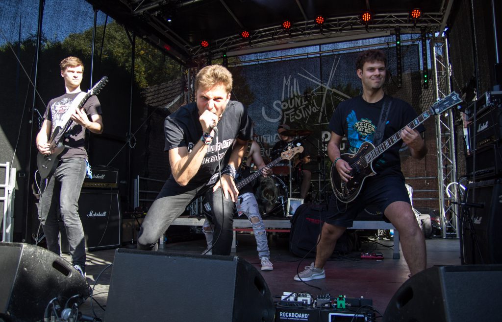Junge Musiker mit Gesang und Gitarren auf einer Open-Air-Bühne